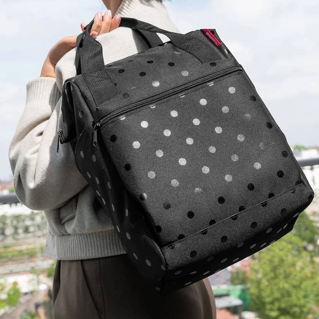 Lieblingstasche Allrounder R insulated backpack in black with grey polka dots worn on a person's shoulder