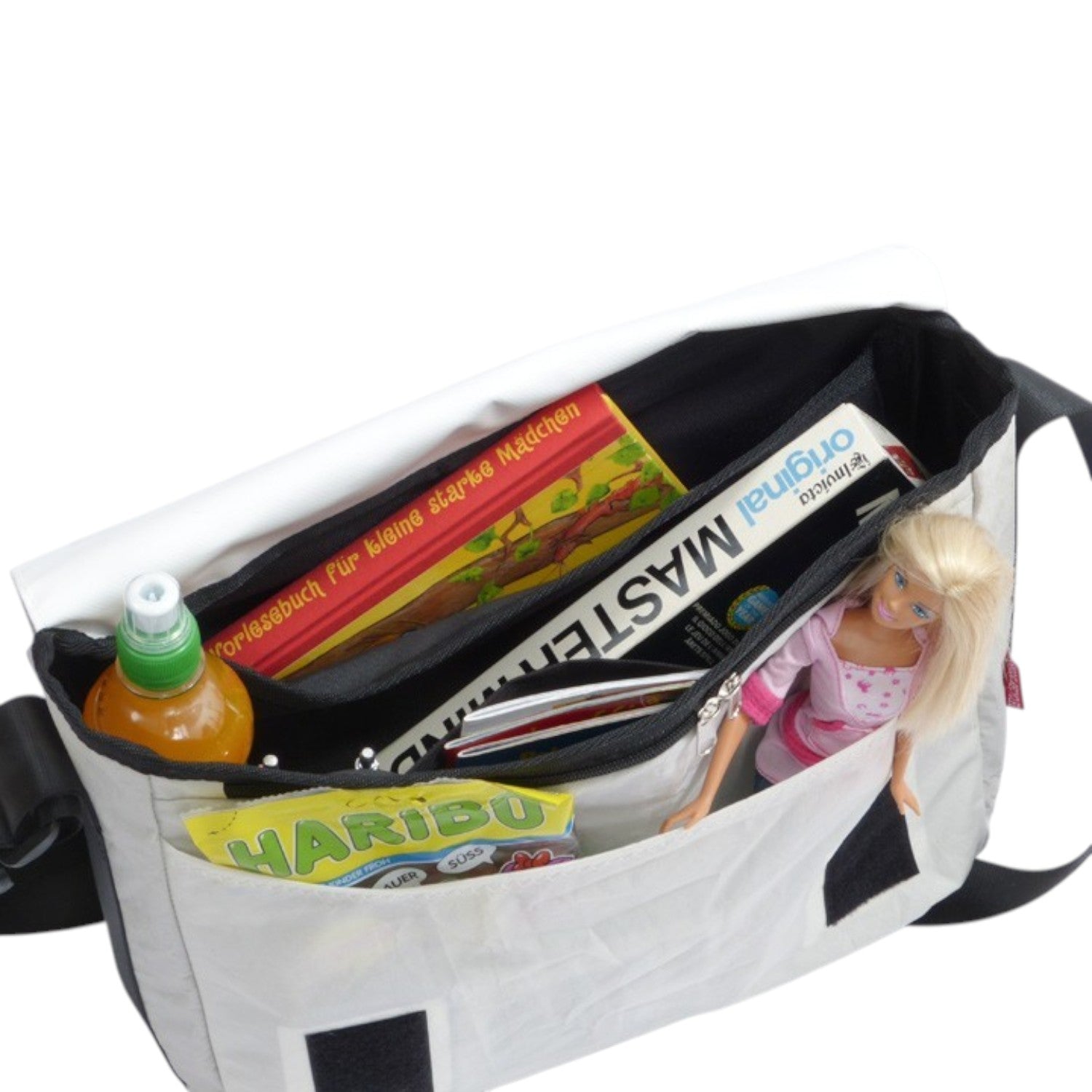 Lieblingstasche Barkasse Mini messenger bag in light grey with black trim, open to reveal contents: book, drink, candy, and doll.
