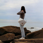 Lieblingstasche Barkasse Mini messenger bag made from recycled white sailcloth worn by a woman at the beach