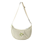 Lieblingstasche beige crescent-shaped sling bag with an adjustable strap and a bright green carabiner detail.