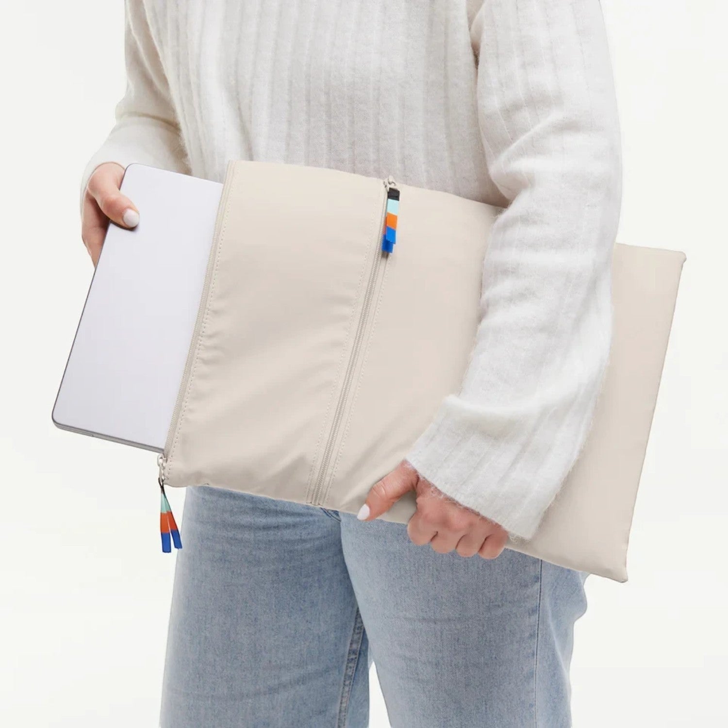 Lieblingstasche beige removable laptop sleeve for 15 inch laptop with colorful zipper pulls held by a person