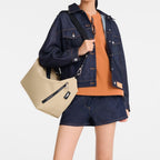 Model wearing a beige Lieblingstasche Le Pliage Energy crossbody bag with black logo strap and denim outfit