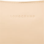 Close-up of a beige leather Lieblingstasche shoulder bag featuring the embossed Longchamp logo and gold zipper detail.