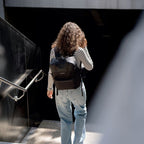 Lieblingstasche Bergen Pro black laptop backpack worn by a woman with curly hair in a striped shirt and jeans