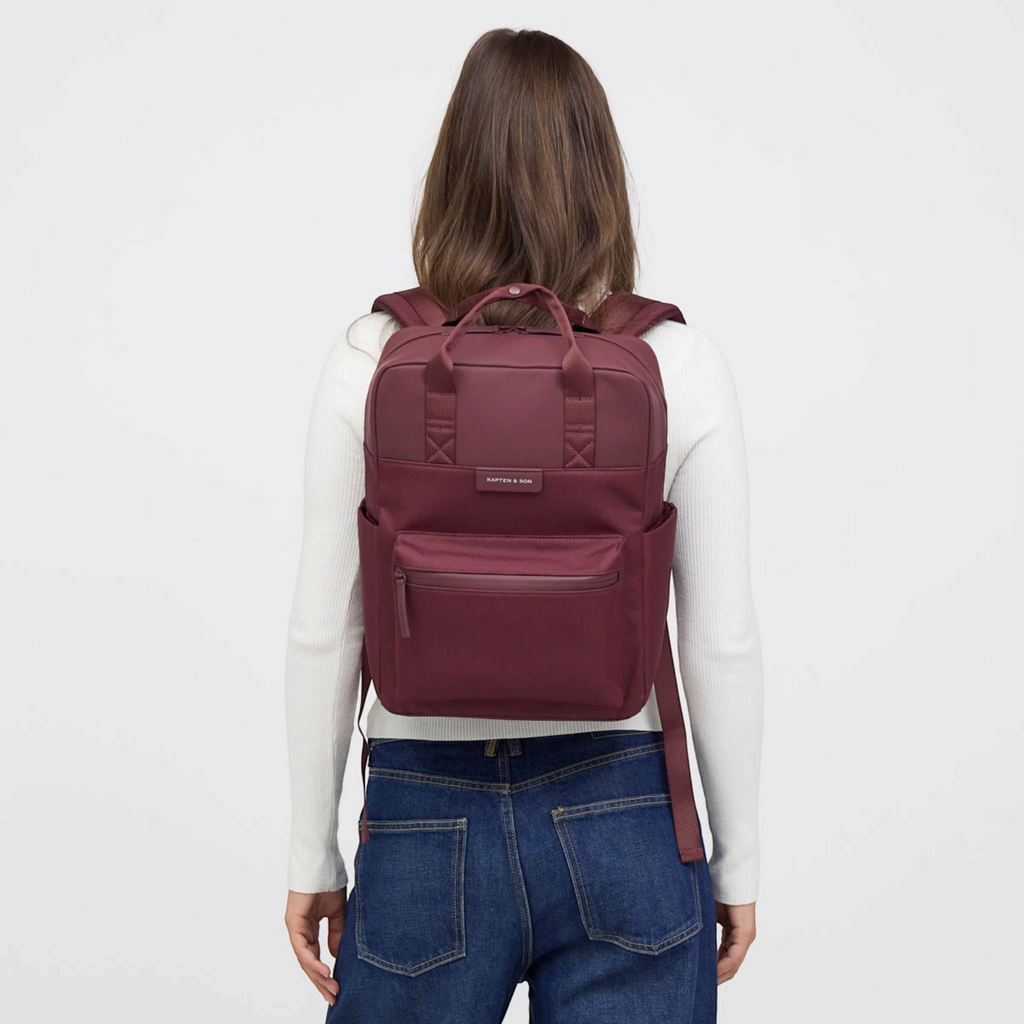 Lieblingstasche Bergen Pro backpack in burgundy worn by a woman against a white background