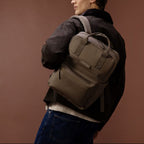 Lieblingstasche Bergen Pro backpack in olive green worn by a man against a brown background