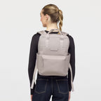 Lieblingstasche Bergen Pro backpack in light taupe worn by a woman against a plain white background