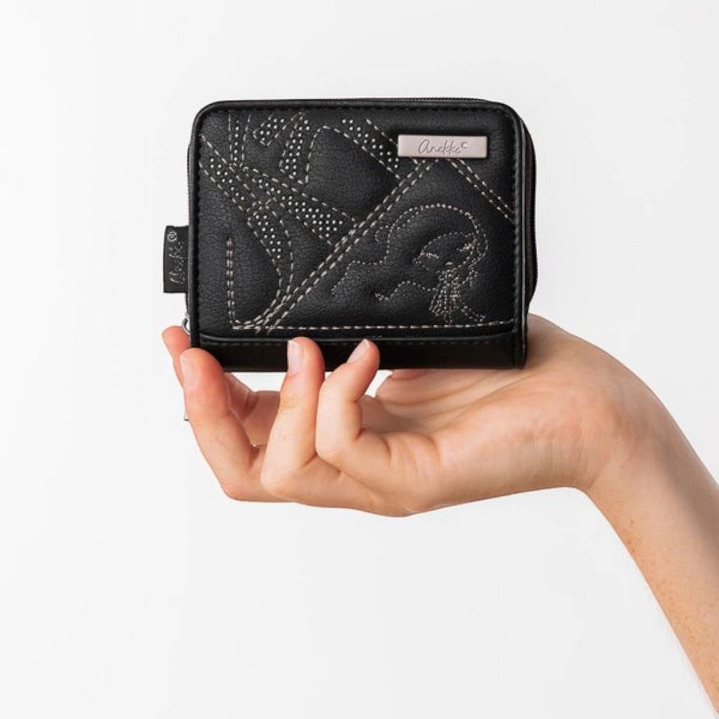 Lieblingstasche black Anekke wallet with decorative stitching held in a hand against a white background