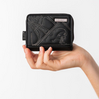 Lieblingstasche black Anekke wallet with decorative stitching held in a hand against a white background