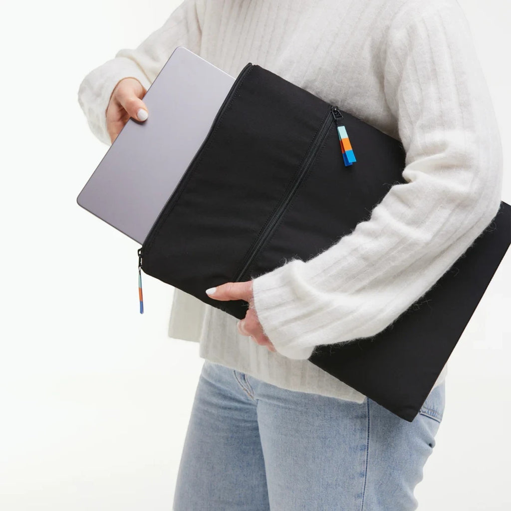 Lieblingstasche black removable laptop sleeve for 15 inch laptop with zipper closure held by a person