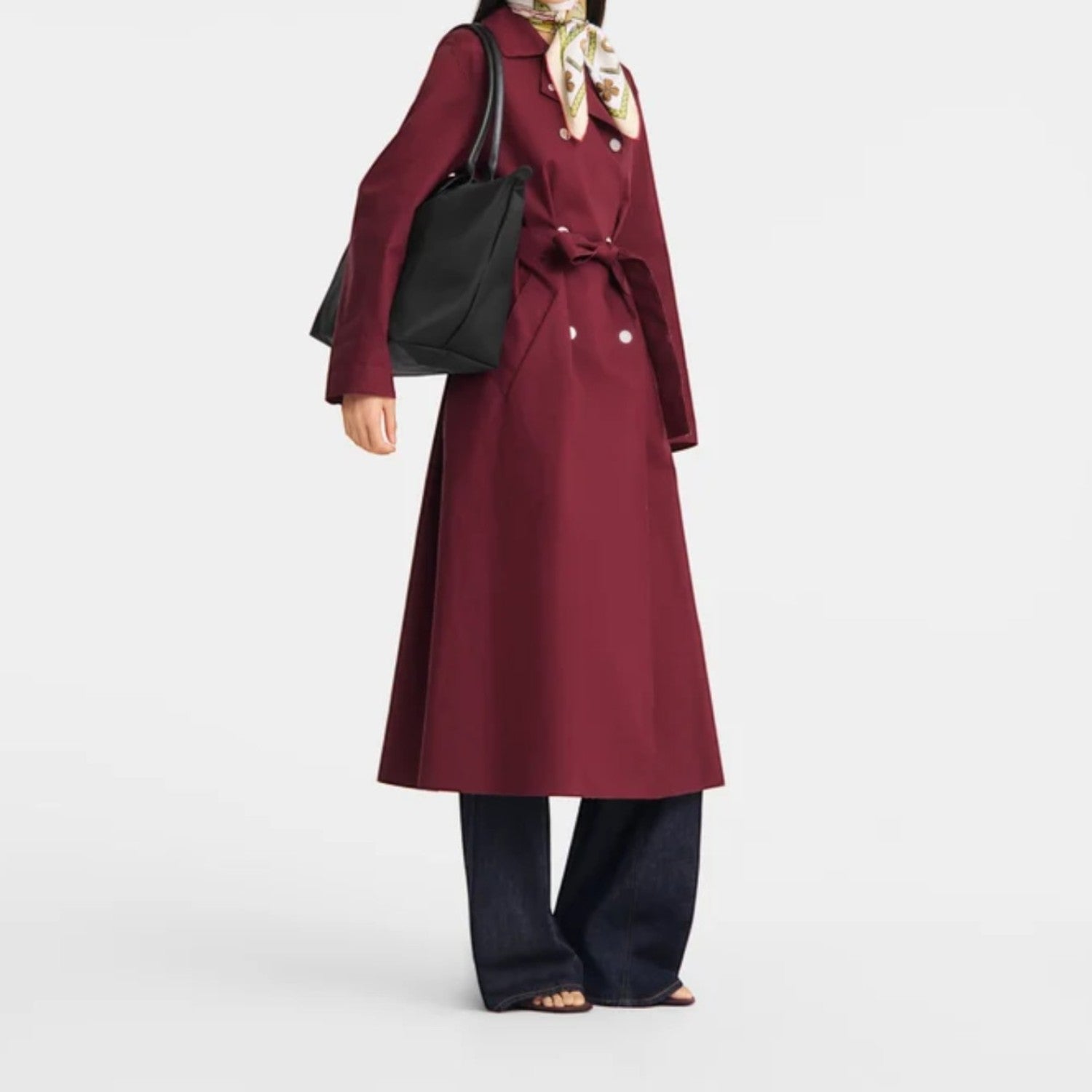 Lieblingstasche black nylon tote bag with leather handles, worn by a woman in a burgundy trench coat.