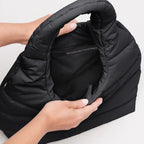 Lieblingstasche black wavy puffer shoulder bag with recycled material interior label held by hands