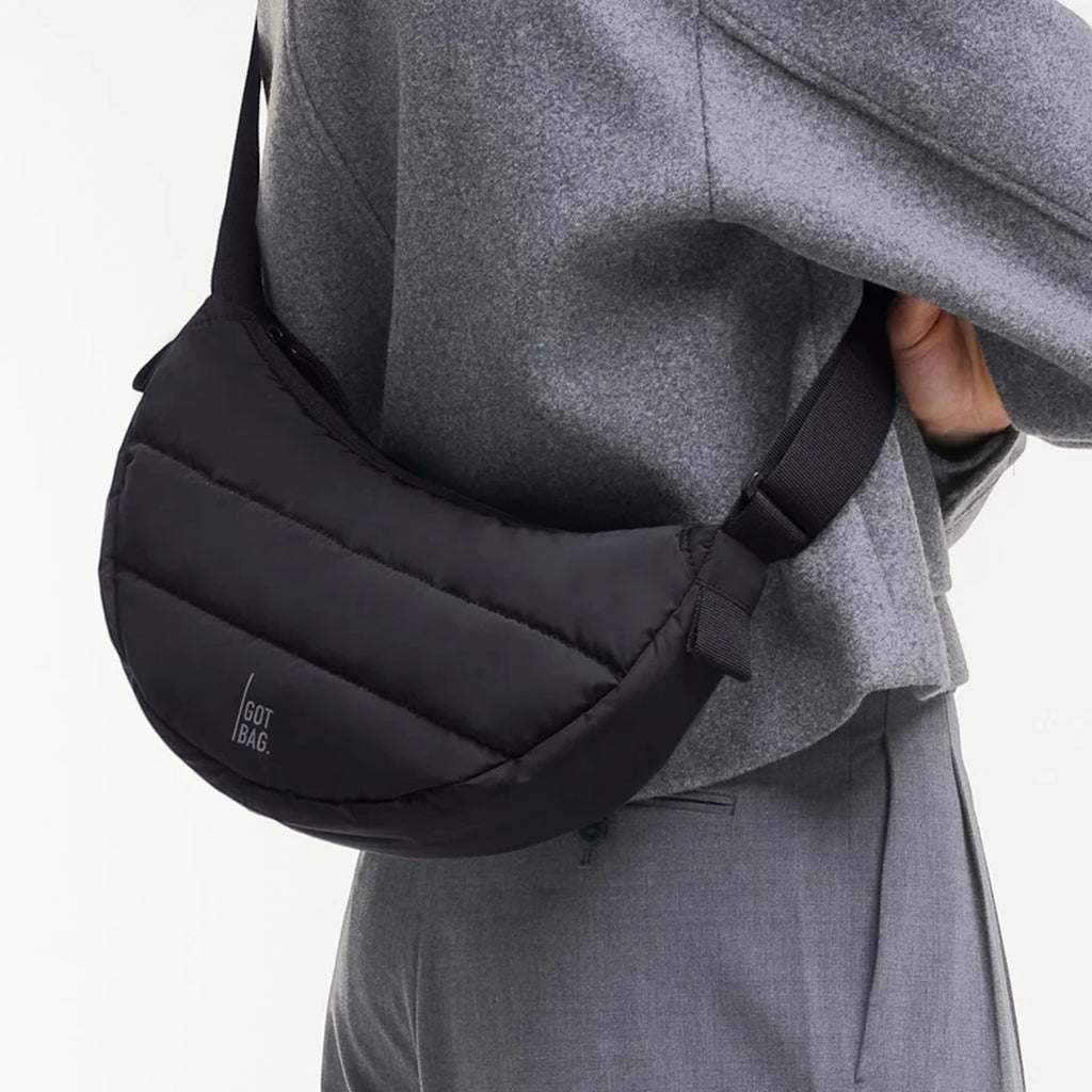 Lieblingstasche black quilted Puffer Moon Bag worn as a crossbody bag made from recycled fishing nets