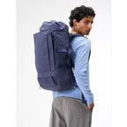 Lieblingstasche Blok Large navy blue roll-top backpack worn by a man against a white background