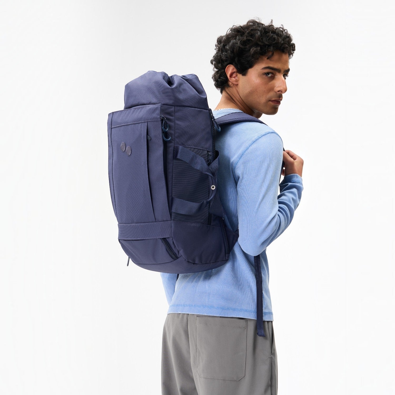 Lieblingstasche Blok Medium backpack in dark blue worn on the back by a man in a light blue long-sleeve shirt