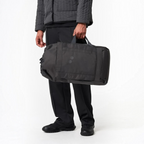 Lieblingstasche Blok Medium charcoal grey duffel bag held by a person wearing matching dark casual clothing