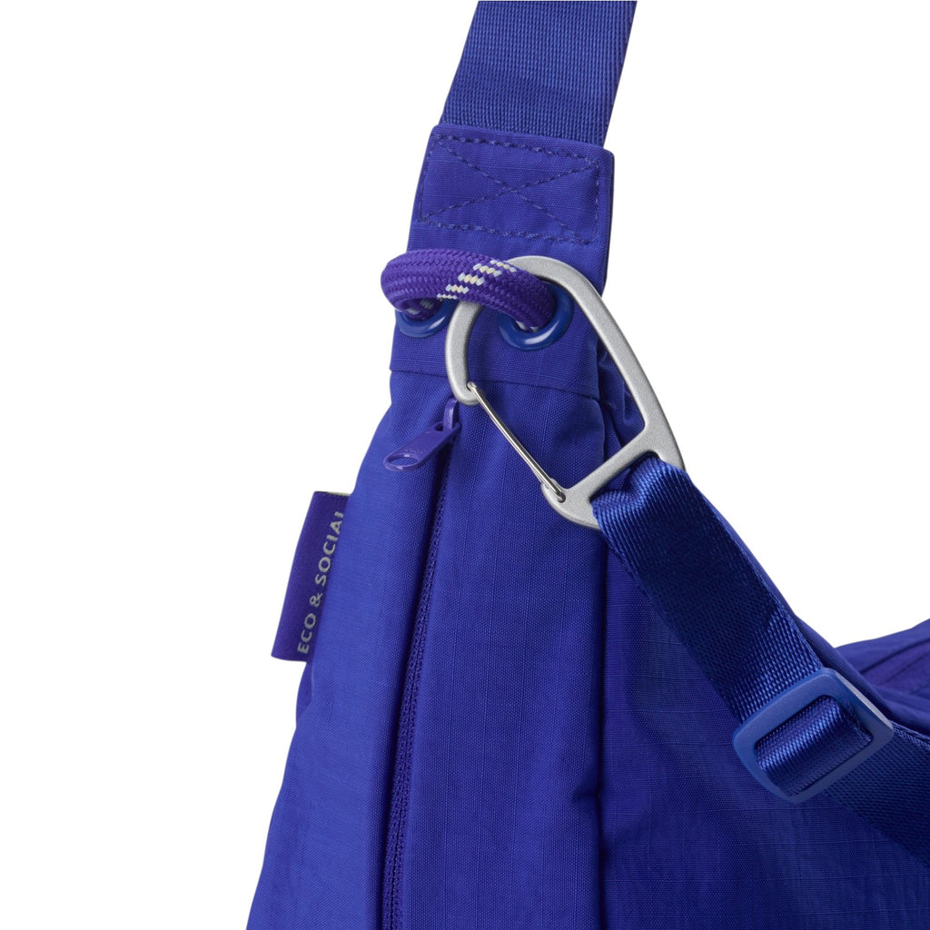 Lieblingstasche blue sling bag featuring a silver carabiner clip, adjustable strap, and eco-friendly fabric detail.