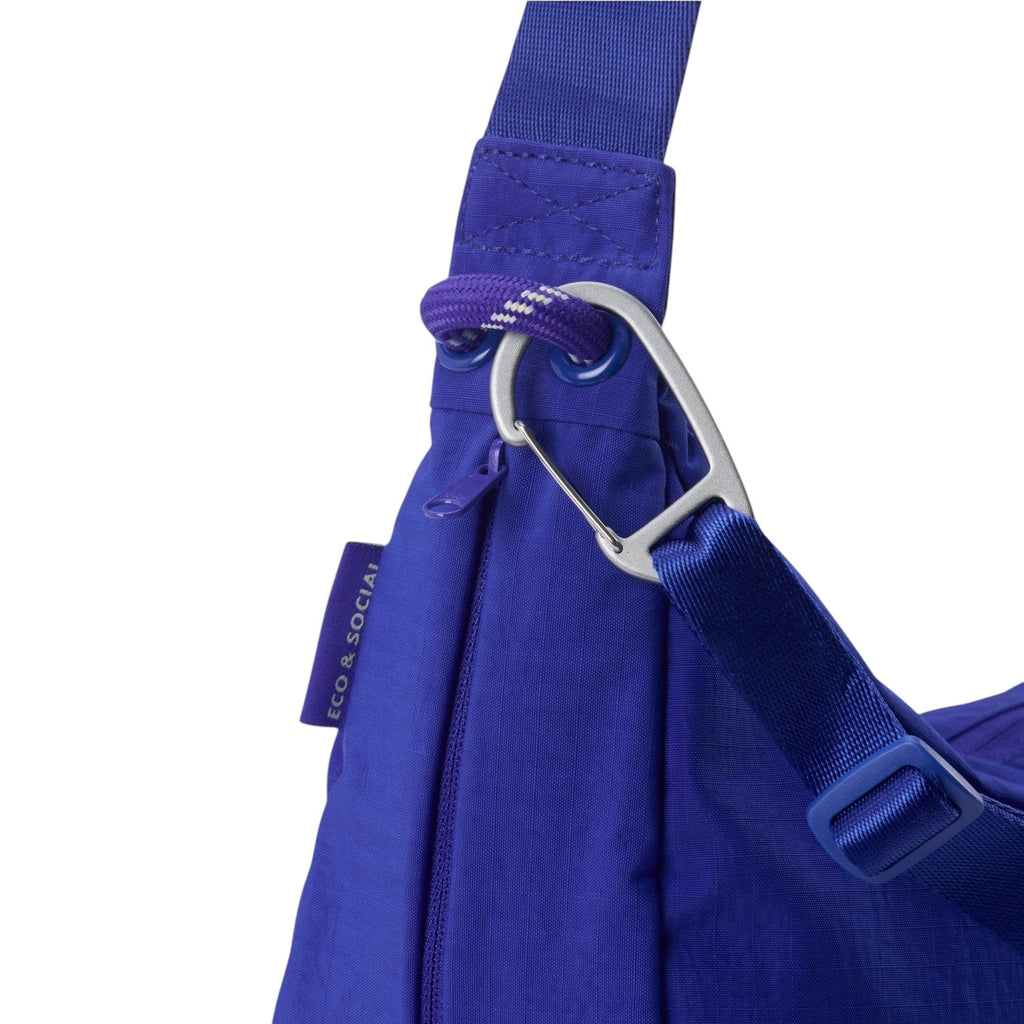 Lieblingstasche blue sling bag featuring a silver carabiner clip, adjustable strap, and eco-friendly fabric detail.