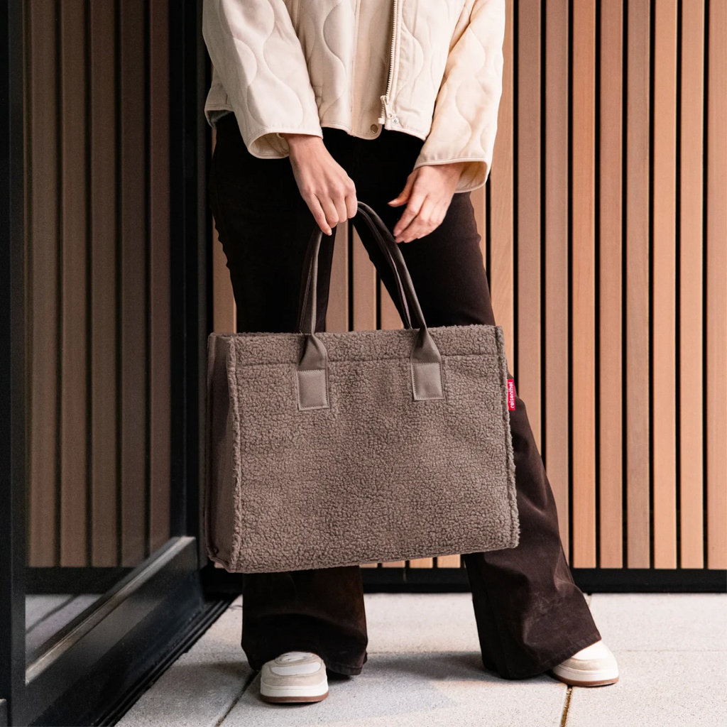 Lieblingstasche Daily Shopper bag in brown teddy fleece material with sturdy handles held by a person