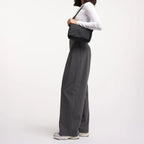 Model wearing a black Lieblingstasche Cloud Crossbody Bag made from water-resistant RE:NYNET material.