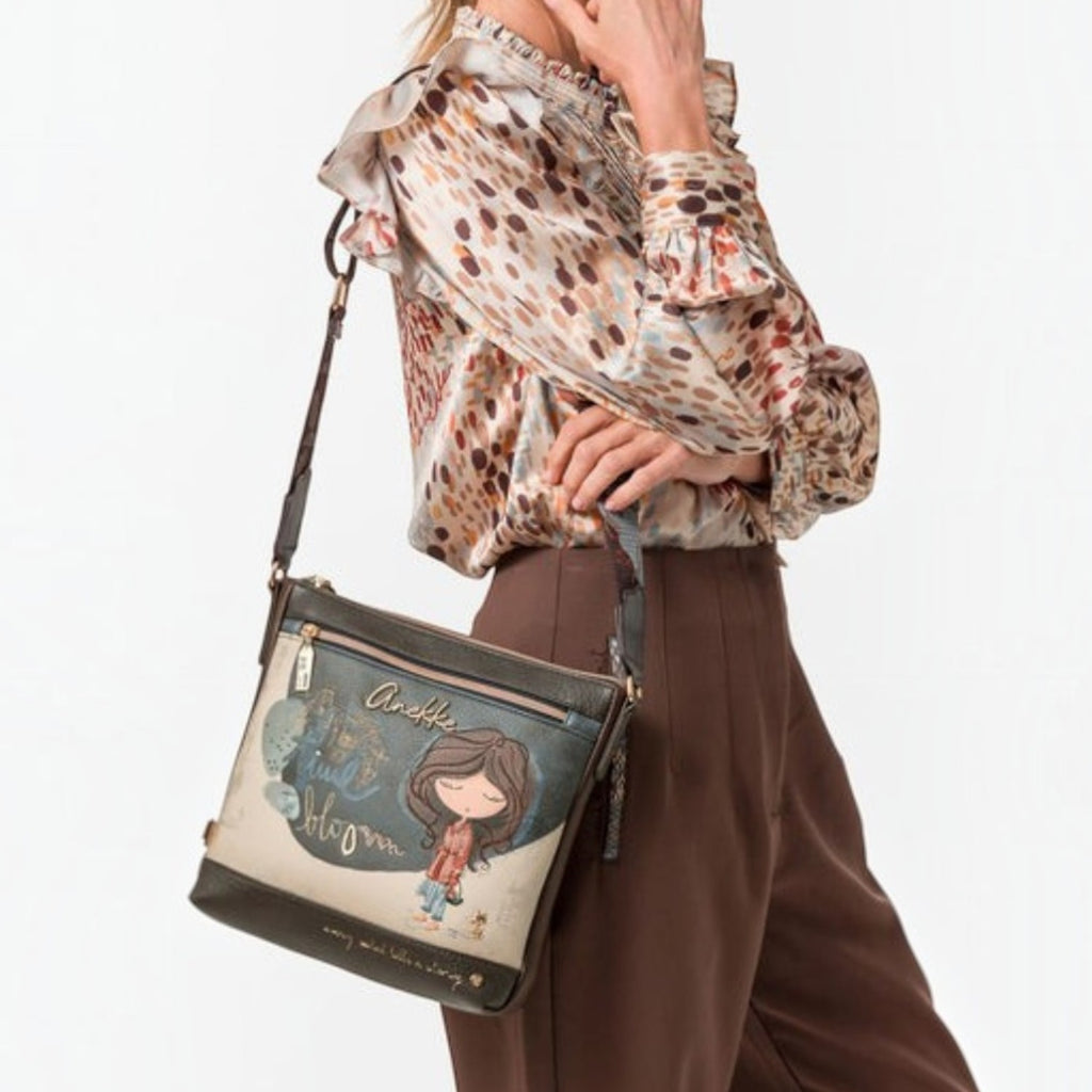 Lieblingstasche cross-body bag featuring a whimsical girl illustration, worn by a model in a brown blouse and trousers