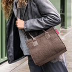 Lieblingstasche Daily Shopper XS in brown teddy fleece material worn over the shoulder by a woman
