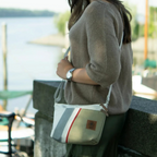 Lieblingstasche Deern Lütt crossbody bag in olive and white canvas with grey and red striped detail worn outdoors