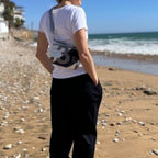 Lieblingstasche Deern Lütt crossbody bag made from recycled sailcloth with number print, worn by woman on the beach