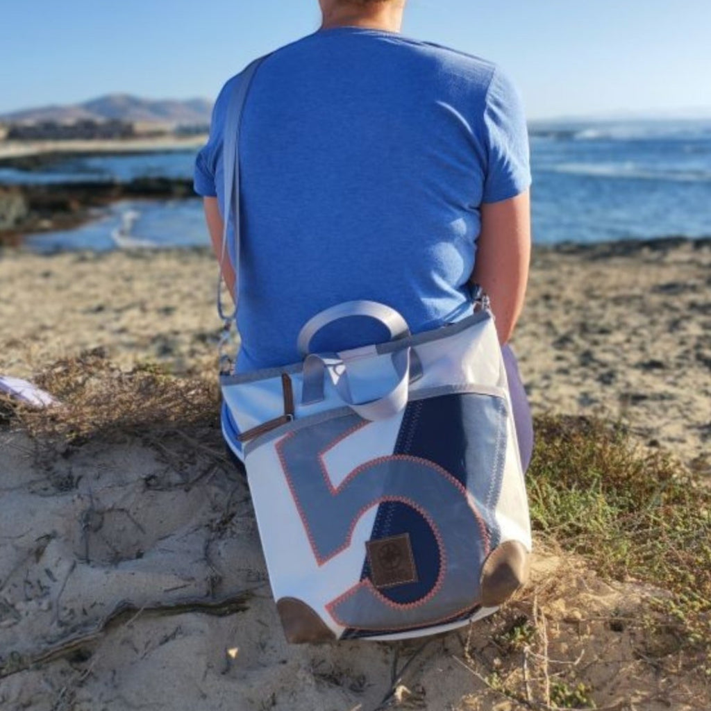 Lieblingstasche Deern Mini handbag made from recycled white and blue sailcloth with a number 5 print on the beach