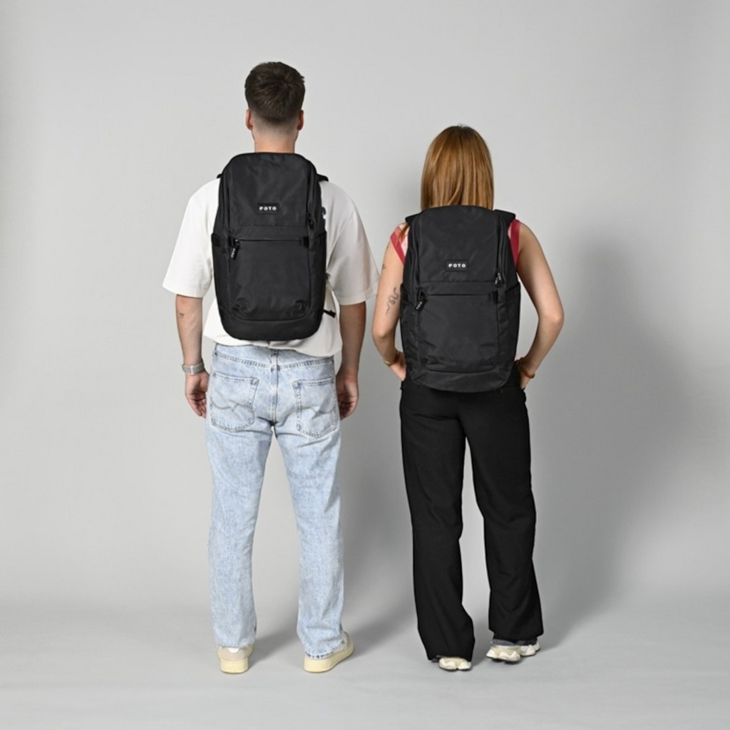 Lieblingstasche Easy27 black everyday backpack worn by a man and woman, showing back view and padded shoulder straps.