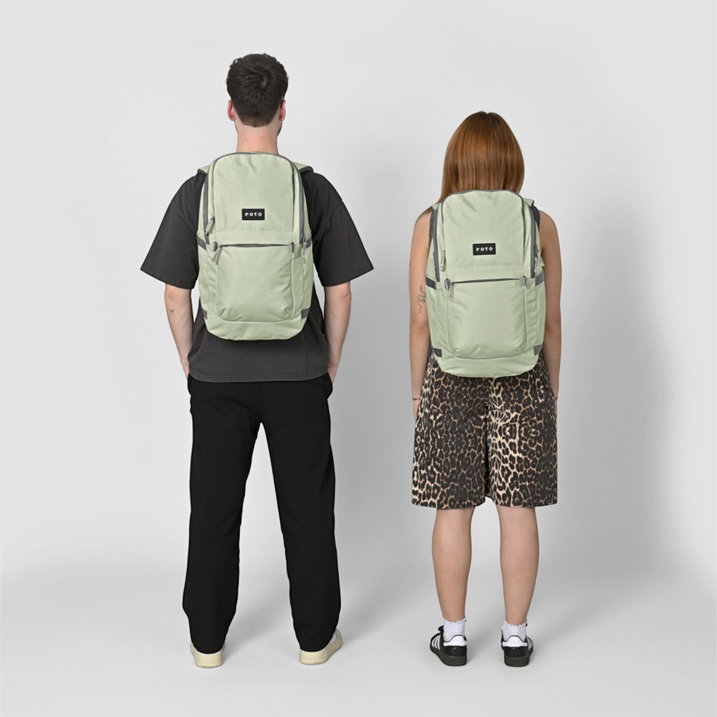 Two people wearing sage green Lieblingstasche Easy27 backpacks with a clean, modern design and front zip pockets.