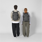 Lieblingstasche eoto Midi20 grey city backpacks worn by a man and a woman against a light grey background