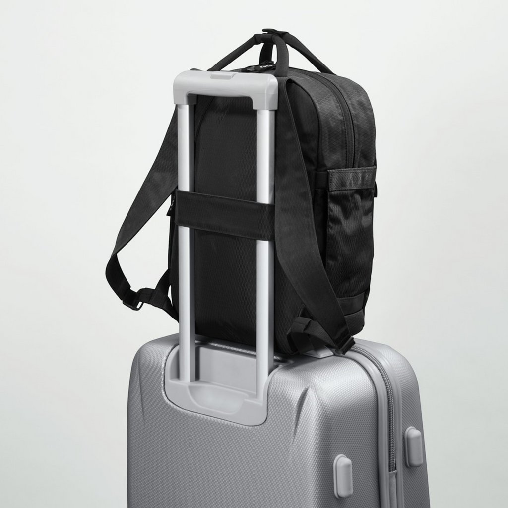 Lieblingstasche eoto Small16 black daypack attached to a silver suitcase handle for travel