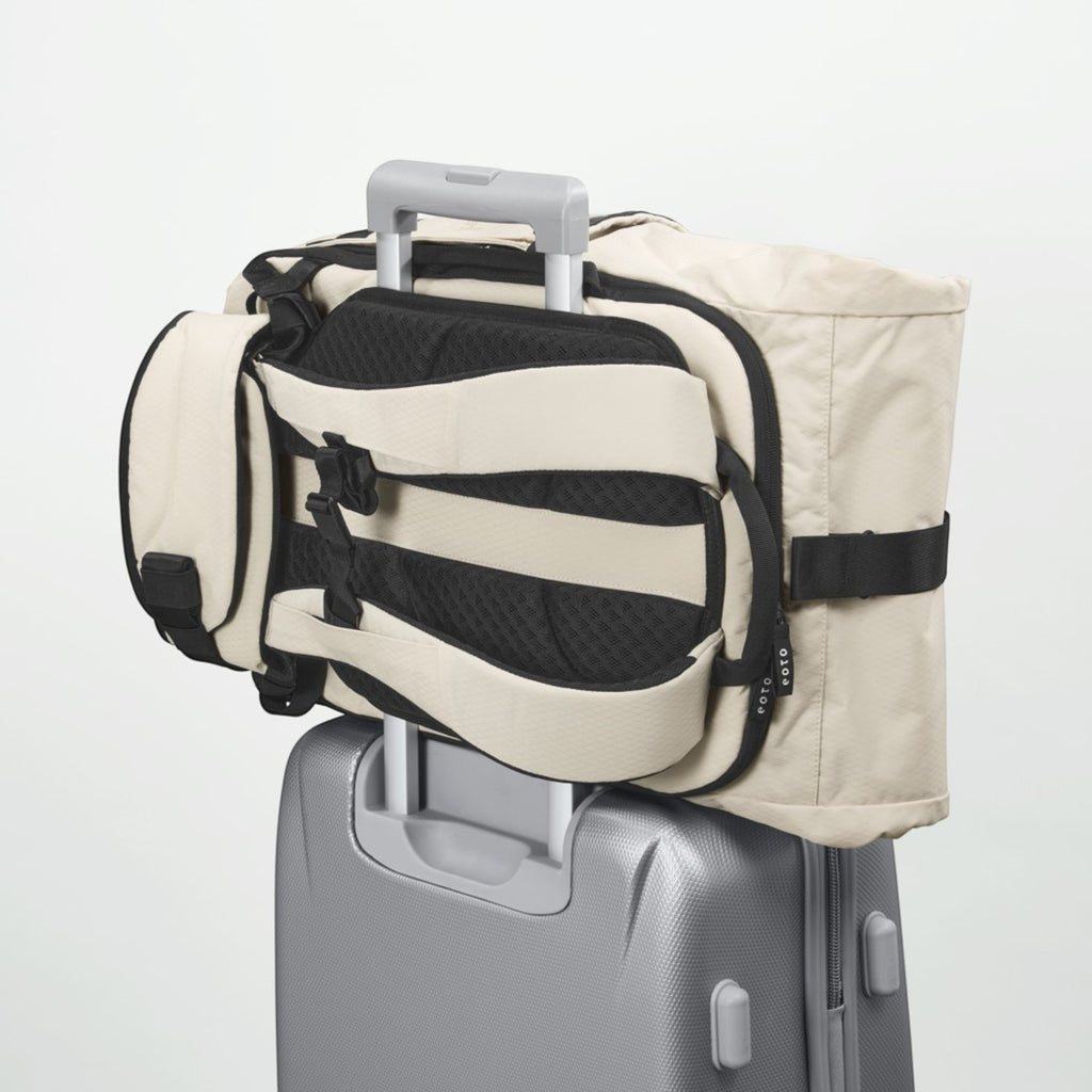 Lieblingstasche eoto Tall41 beige rolltop travel backpack with trolley sleeve attached to a suitcase handle