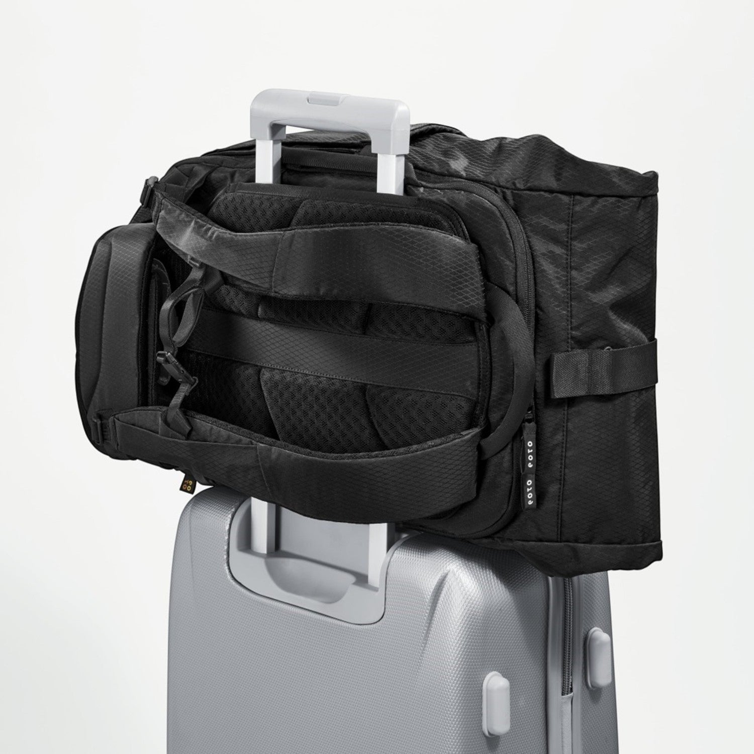 Lieblingstasche eoto Tall41 black travel backpack with trolley sleeve attached to a silver suitcase handle