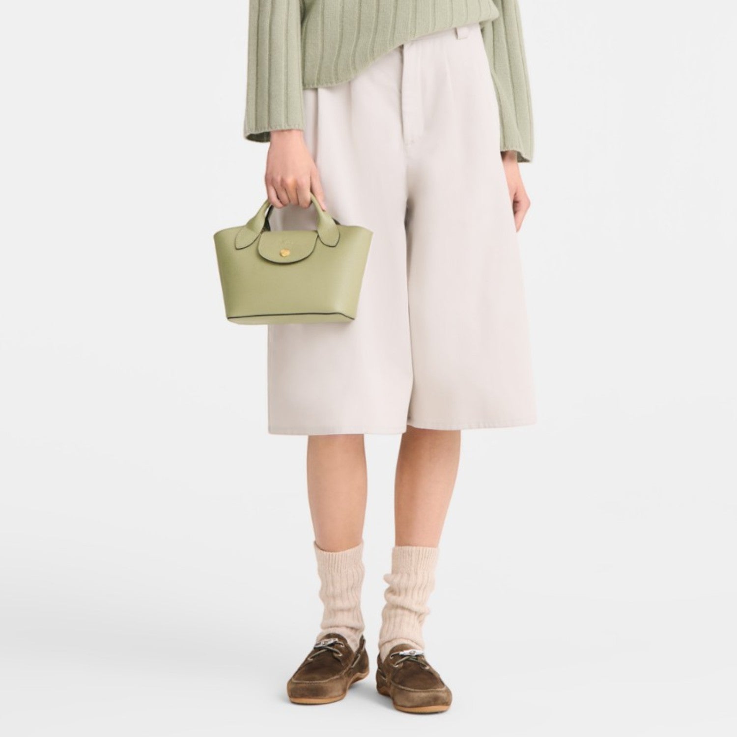 Lieblingstasche Epure Umhängetasche XS, a small light green leather handbag with a top handle and a gold clasp.