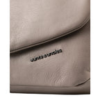Close-up of a taupe leather Fern bag by Lieblingstasche featuring the aunts & uncles metal logo plate.