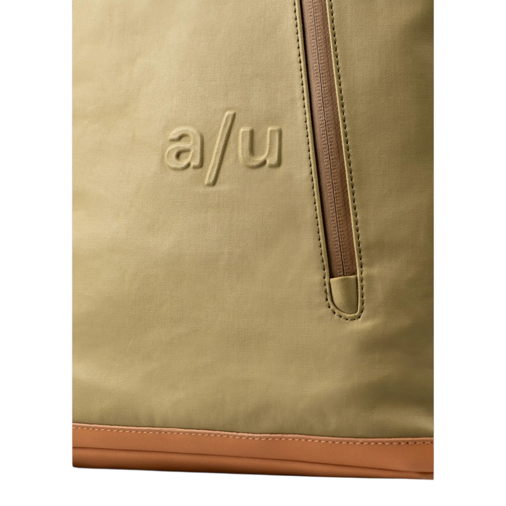 Close-up of the Lieblingstasche a/u Fukui backpack in olive green coated canvas with a vertical front zipper pocket.