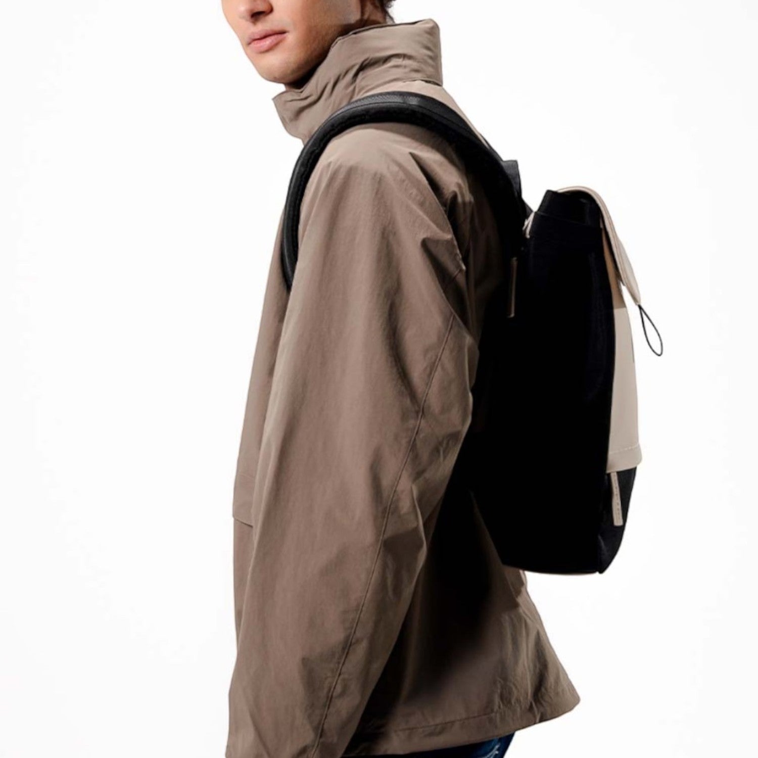Man wearing a black and beige Kapten & Son Fyn backpack from Lieblingstasche, featuring a minimalist design.