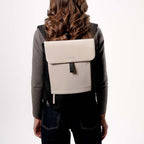 Lieblingstasche Kapten & Son Fyn backpack in beige and black with a minimalist flap design worn by a woman