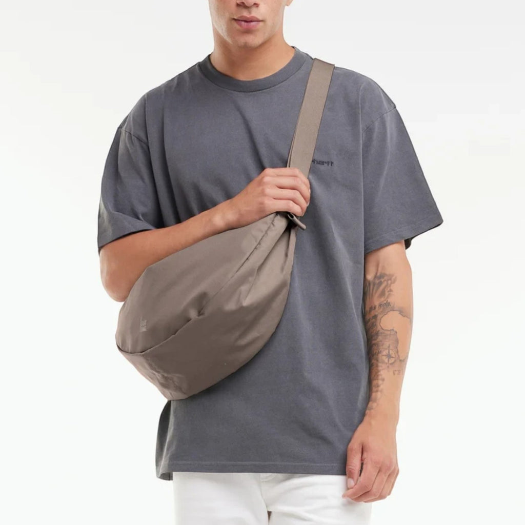 Lieblingstasche GOT BAG Moon Bag Large in taupe worn crossbody by a man in a grey t-shirt