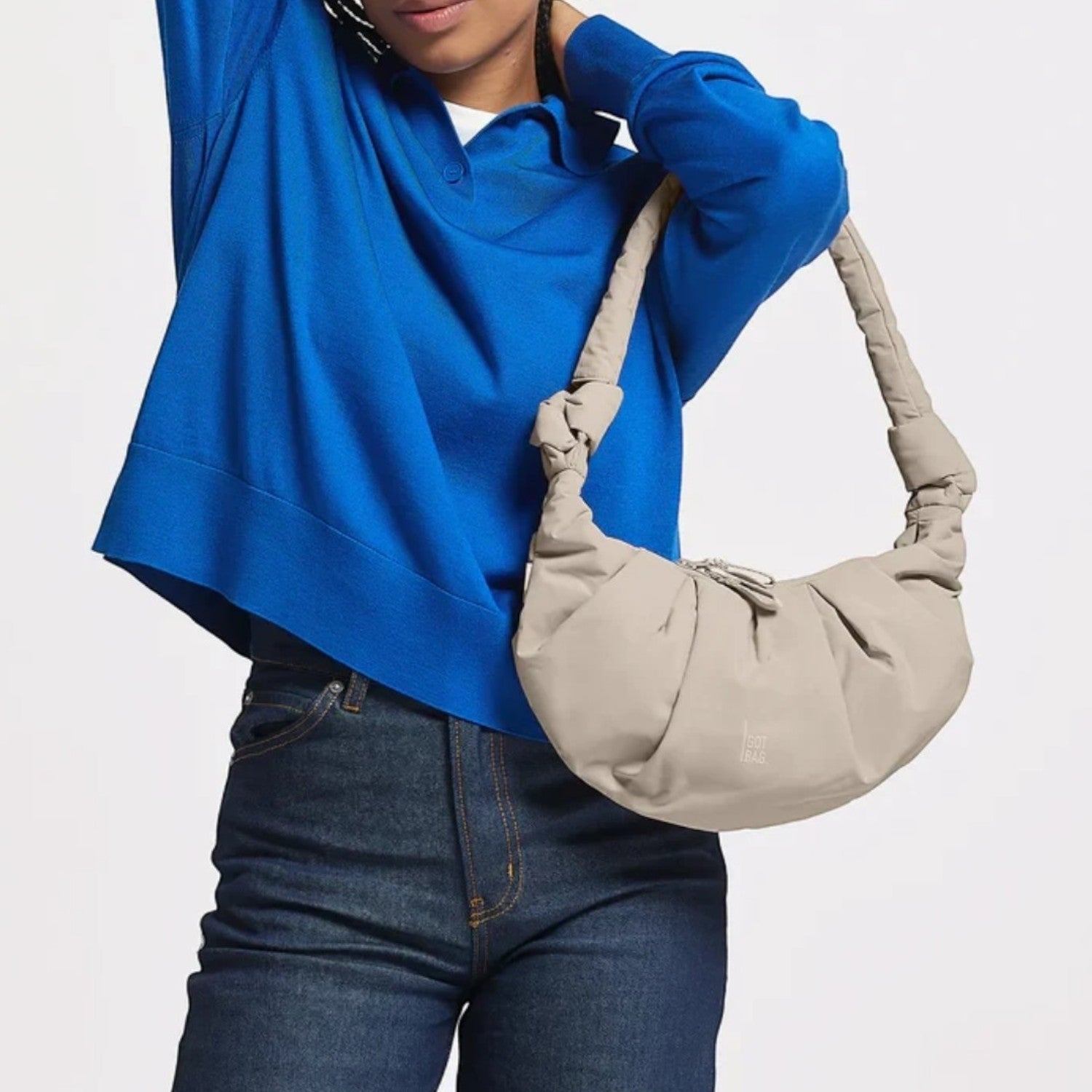 Lieblingstasche GOT BAG Pleat Moon Bag Small in beige, worn as a shoulder bag by a model in a blue sweater.