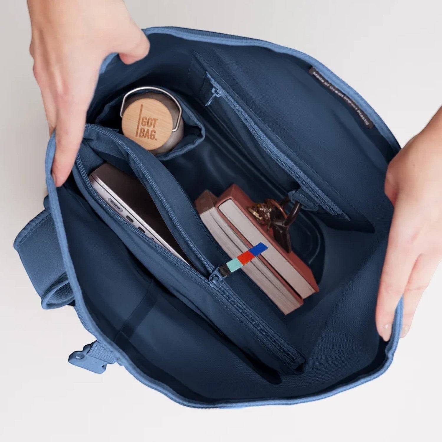Lieblingstasche GOT BAG Rolltop 2.0 backpack interior showing laptop sleeve, water bottle, and books in blue fabric.