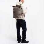 Lieblingstasche GOT BAG Rolltop 2.0 backpack in taupe worn by a man against a white background