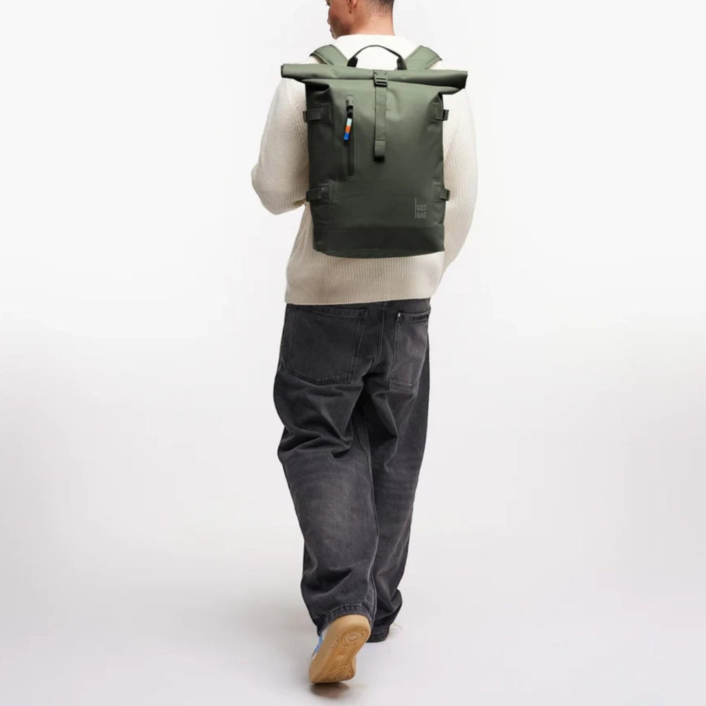 Lieblingstasche GOT BAG Rolltop 2.0 backpack in olive green worn by a man in a white sweater and grey jeans