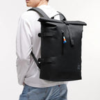 Lieblingstasche GOT BAG Rolltop 2.0 black backpack with magnetic closure worn by a man against a white background