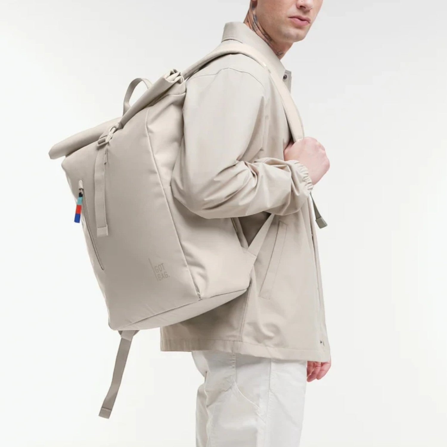 Lieblingstasche GOT BAG Rolltop Easy backpack in beige worn by a man in a matching jacket against a white background