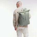 Lieblingstasche GOT BAG Rolltop Easy backpack in sage green, worn by a man in a beige jacket against a white background