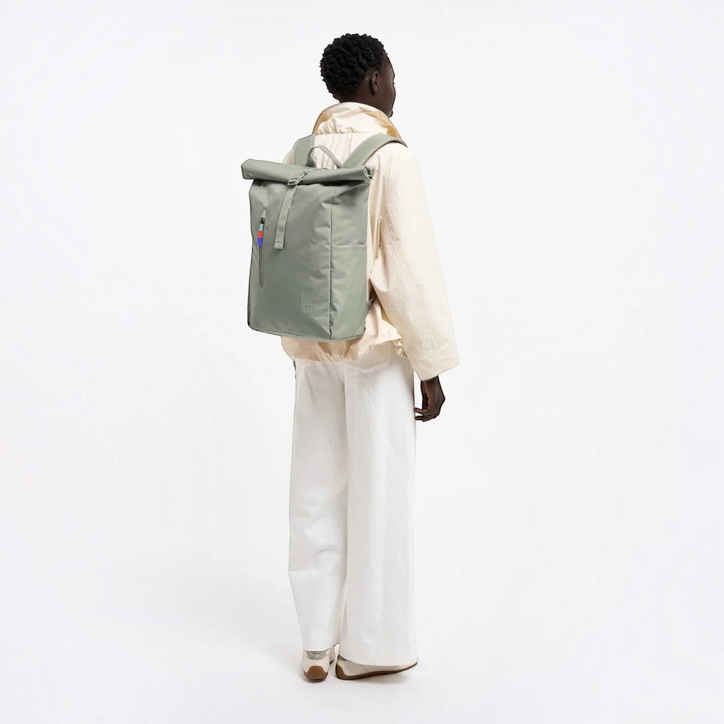 Lieblingstasche GOT BAG Rolltop Easy backpack in sage green worn by a model against a white background