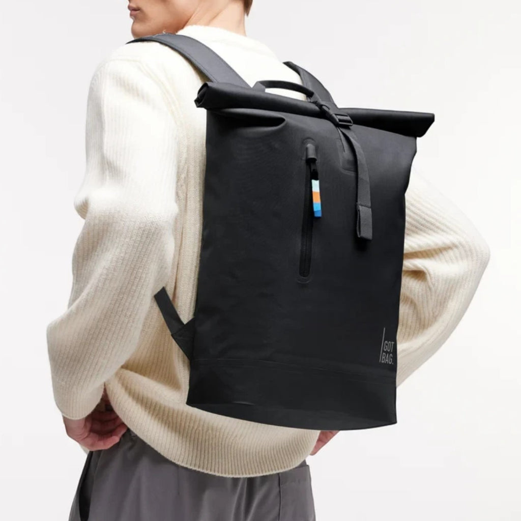 Lieblingstasche GOT BAG Rolltop Lite 2.0 black waterproof backpack worn by a man in a white sweater